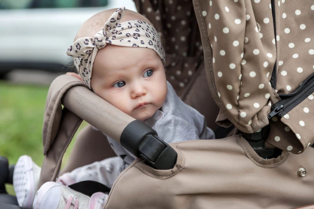 Dziecko siedzi w ekskluzywnym wózku Cybex