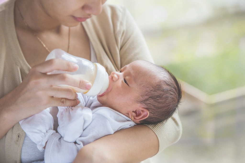 Ulewanie u noworodka 2 Mama karmi dziecko butelką