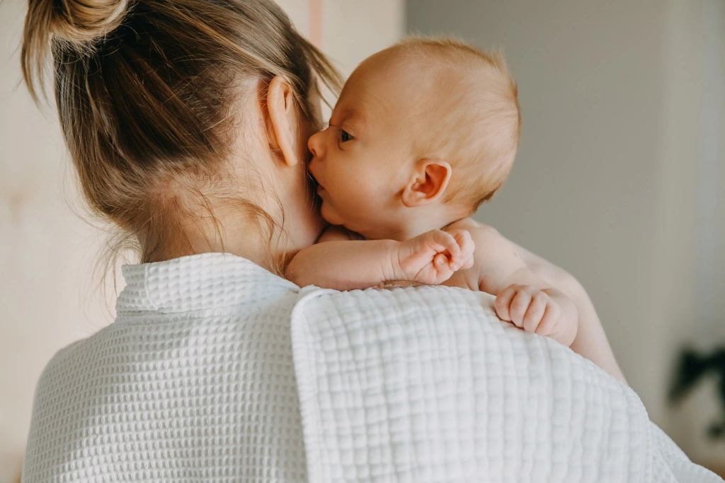 Ulewanie u noworodka 3 Mama trzyma noworodka po karmieniu