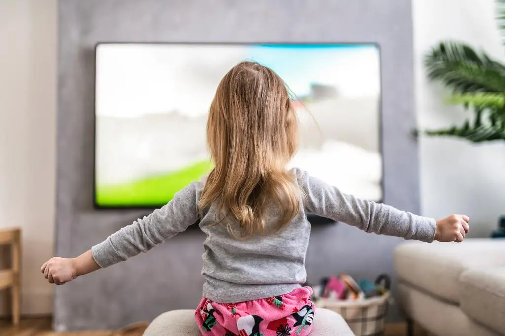 dziewczynka ogląda bajki w telewizji
