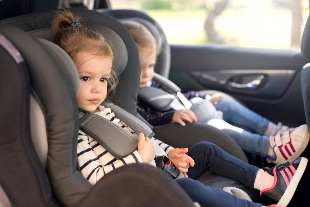 Dzieci siedzą w fotelikach w samochodzie