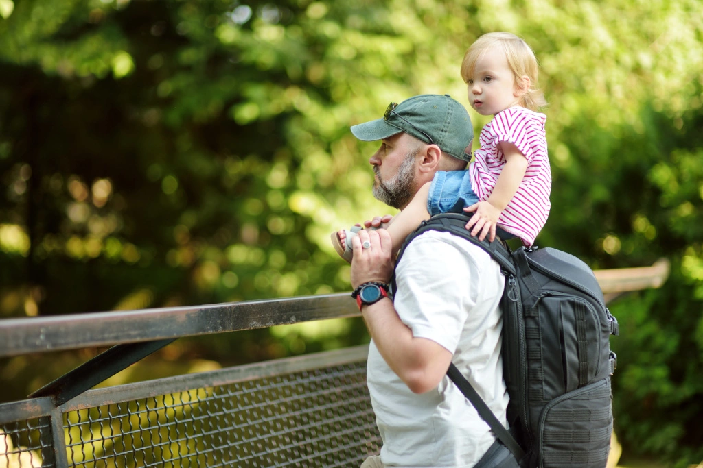 Tata trzyma na baranach małą córeczkę w Muzeum Przyrodniczym