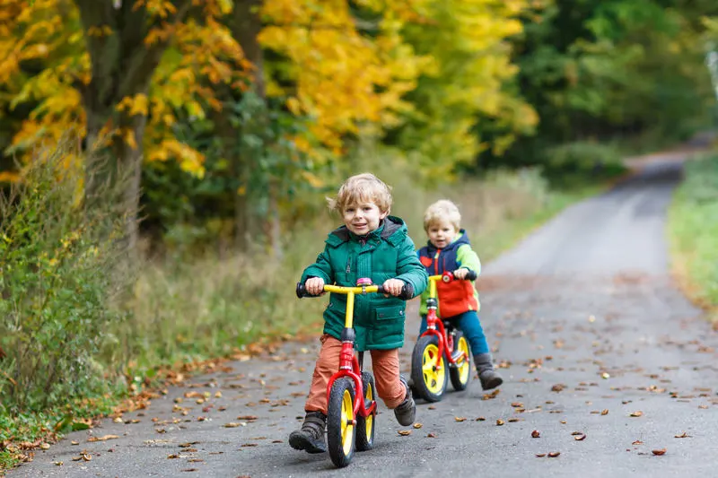 rowerek biegowy dla dwulatka - dwójka dzieci na rowerkach w parku