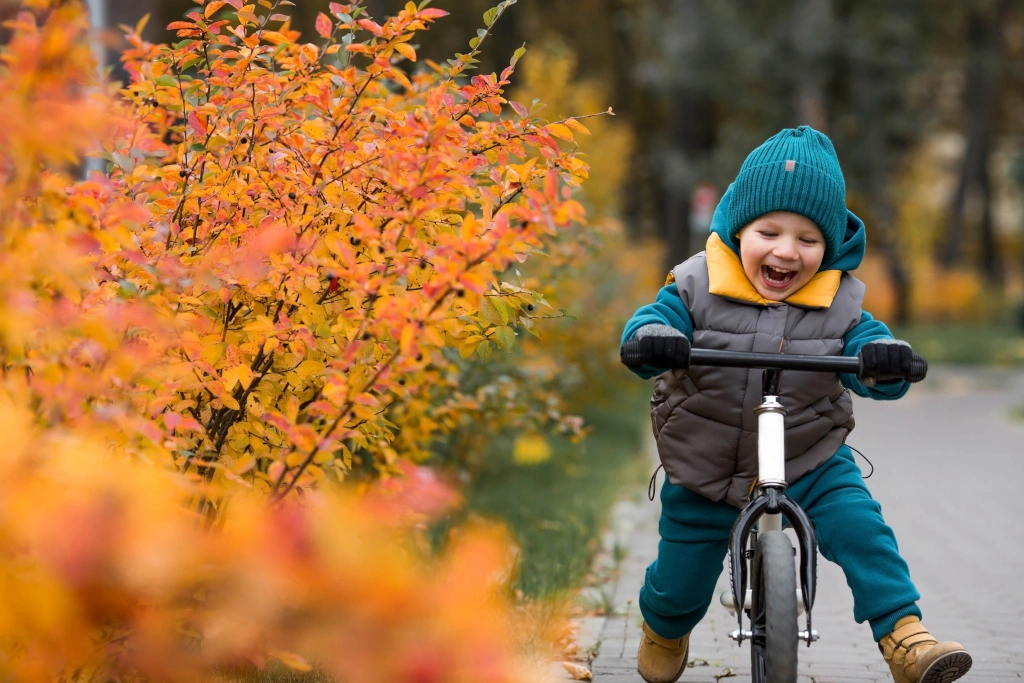 Chłopiec jedzie na rowerku w parku