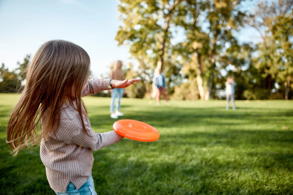 Dziewczynka bawi się z rodzicami w parku